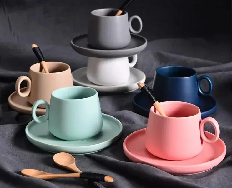 Locally sourced ceramic mugs neatly arranged by a coffee machine.