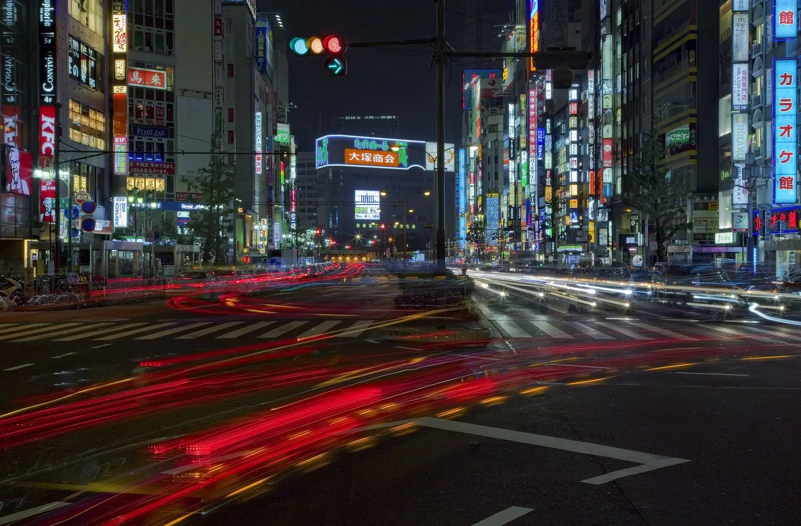 A bustling street crossing in Tokyo at night.